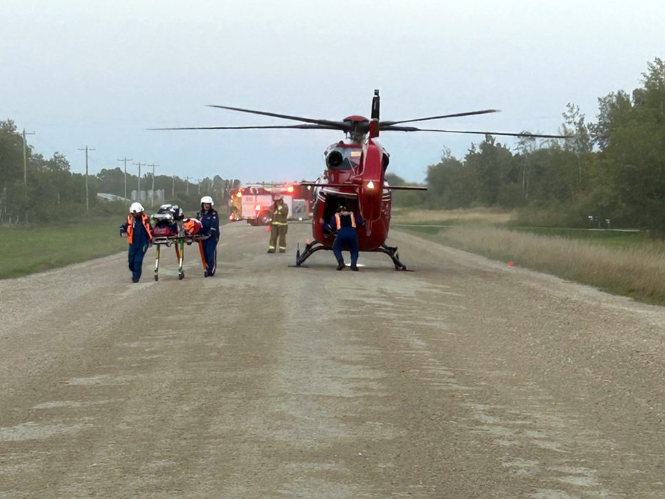 Red helicopter on a gravel road.