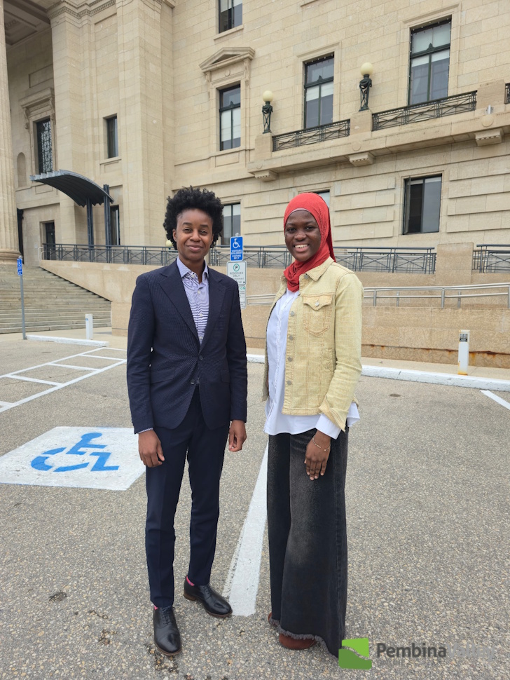two people stand in a parking lot