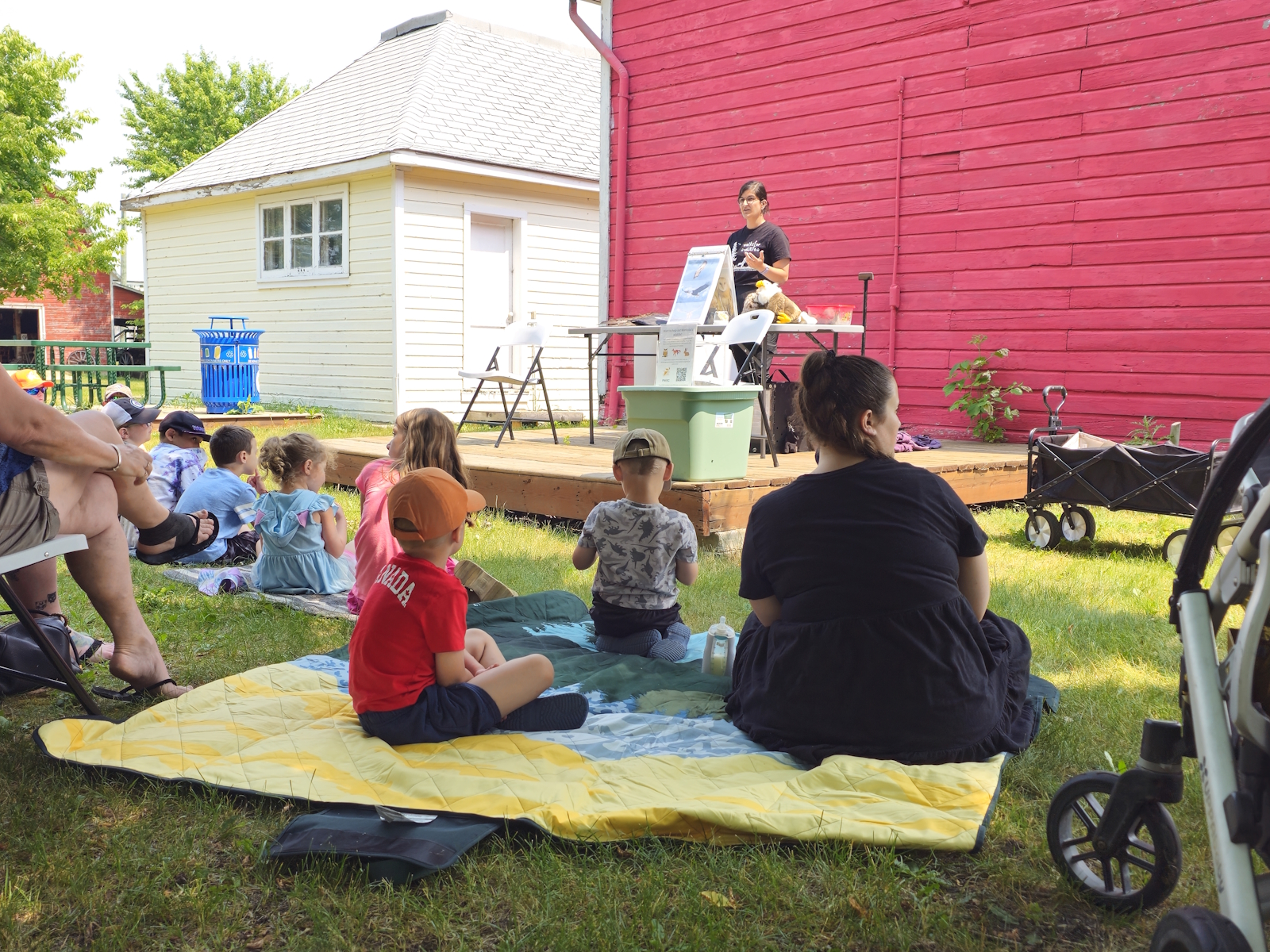Children sit with their families, taking in the presentation in awe