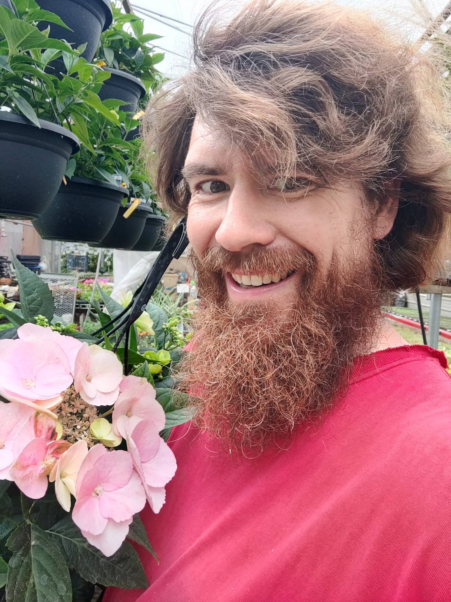Shea Doherty smiling and holding spring flowers at Our Farm Greenhouses