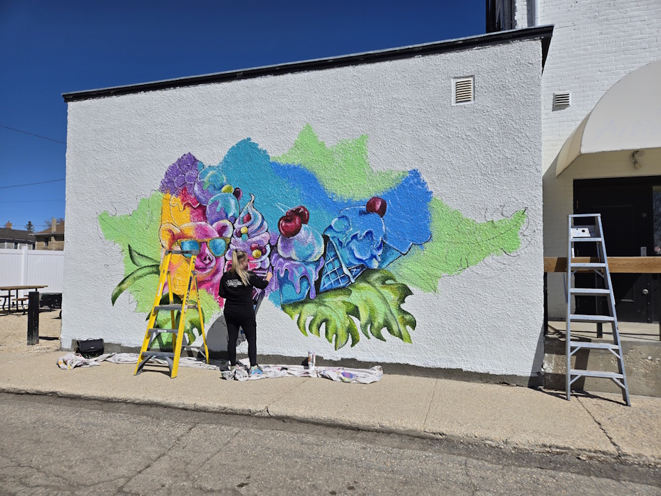 Lancaster painting the new mural outside What's the Scoop on Thursday afternoon in Portage