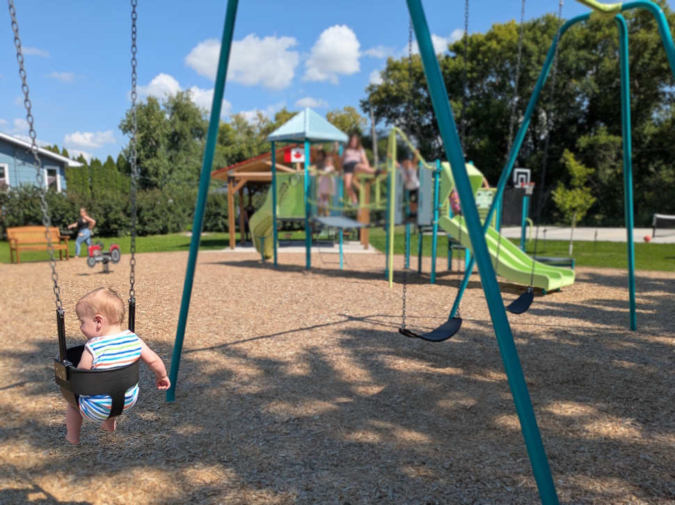 A young visitor enjoys a ride on the new baby swings at Peony Farm Community Park, part of the freshly unveiled play structures designed for all ages. PortageOnline/Maryssa McFadden