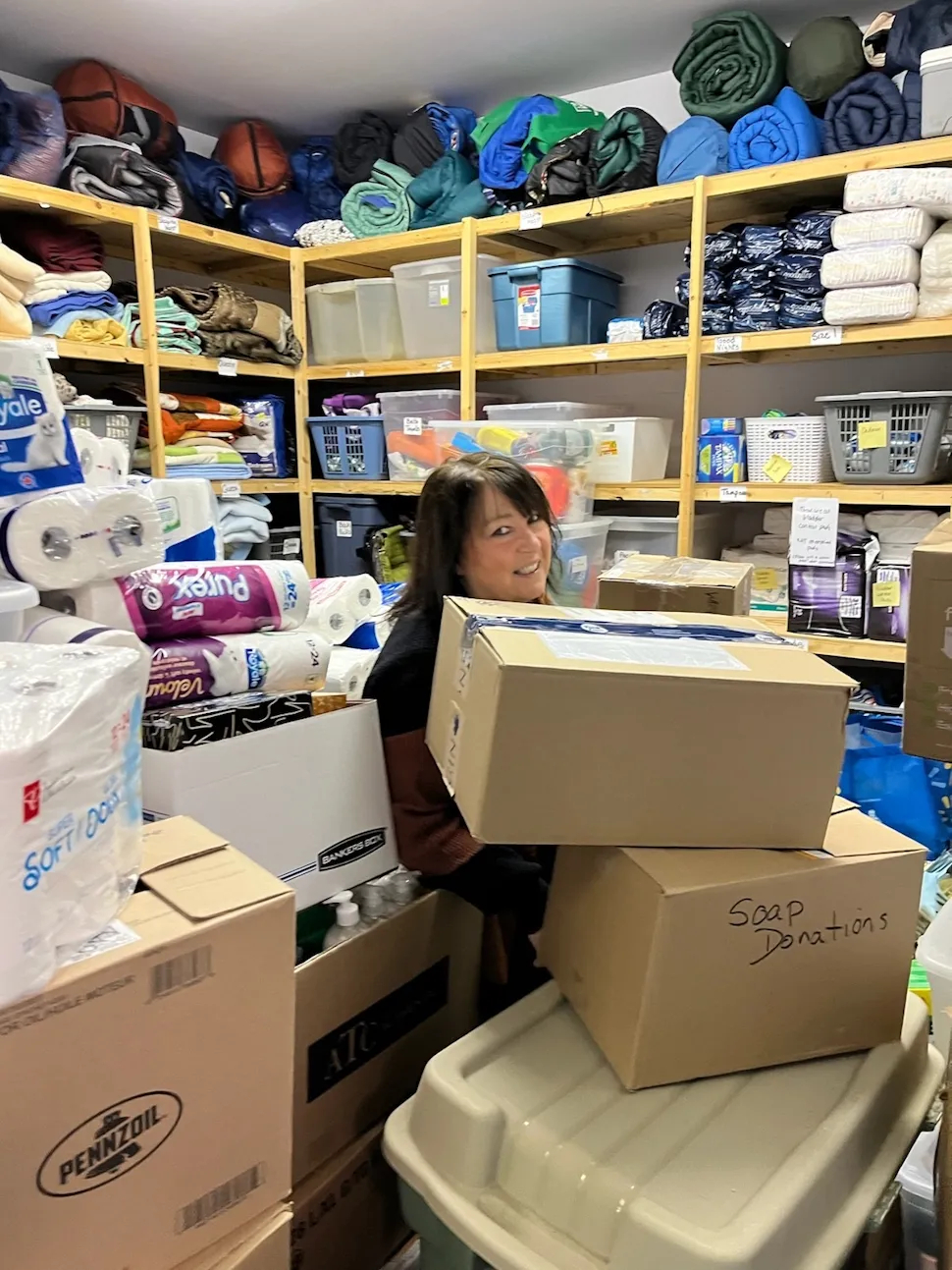 madeleine thiessen in a pile of donations