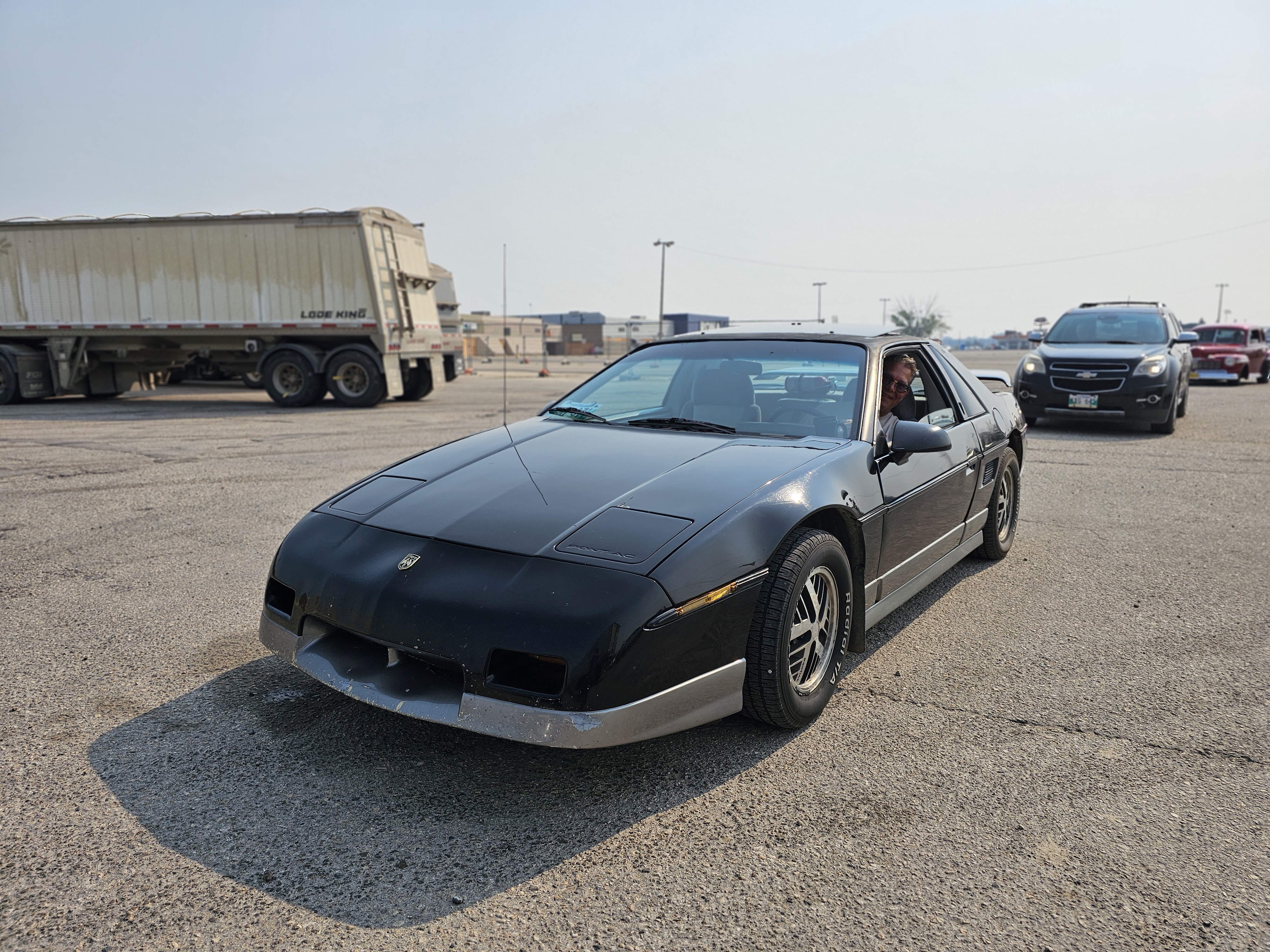 A black Pontiac Fiero, a nod to the 80s sports car era.