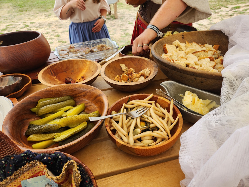  rustic outdoor feast featuring traditional pickled vegetables, fresh bread, and homemade butter, celebrating heritage through simple, hearty flavors.     PortageOnline/ Tristen Sokolosky