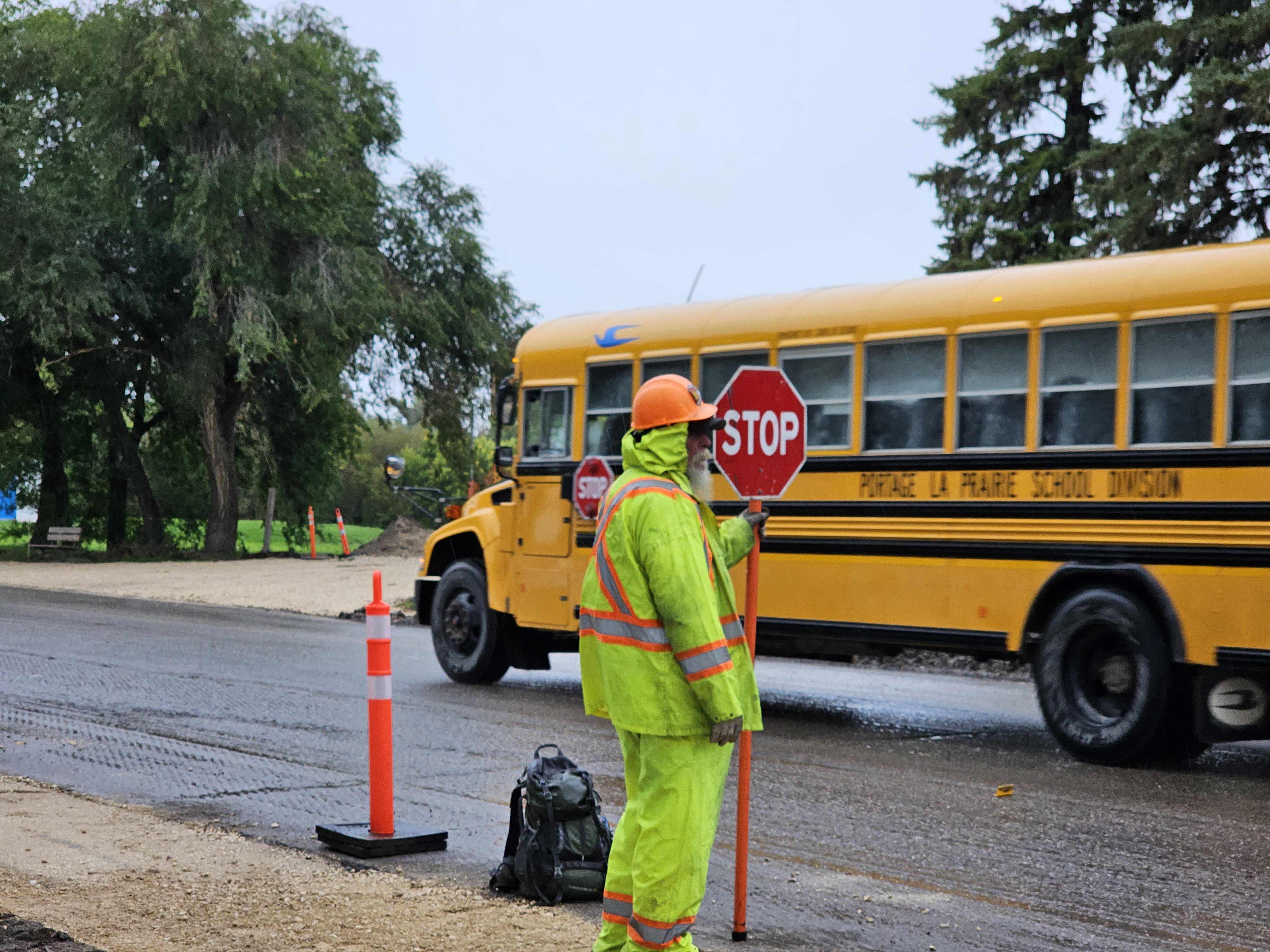A sign-bearer as a school bus passes by