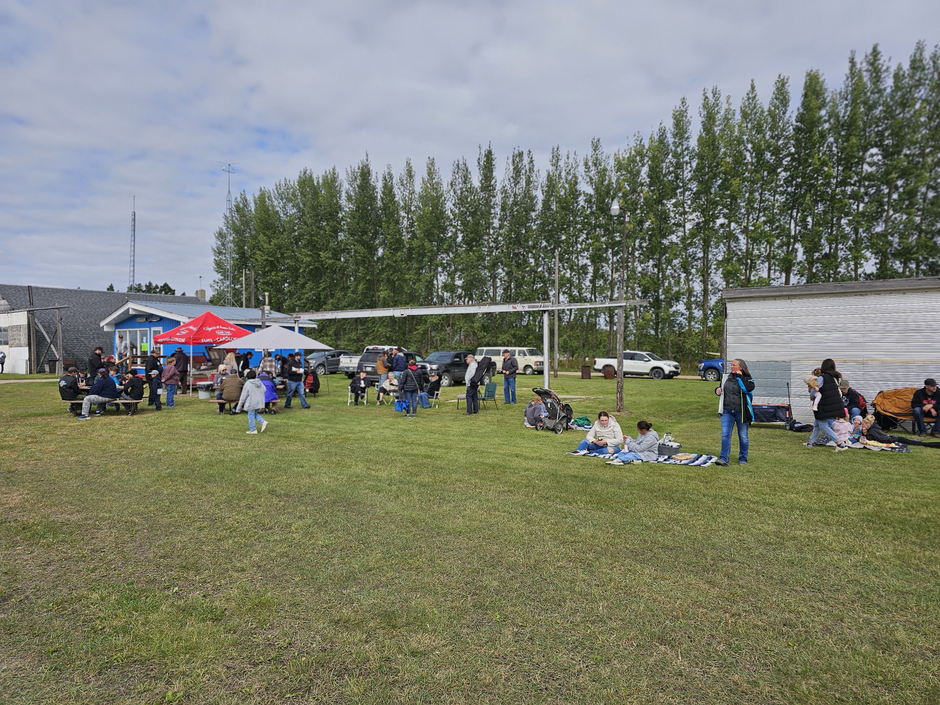A crowd of people gathering at the Gladstone Airport for the Flying Club Fundraiser