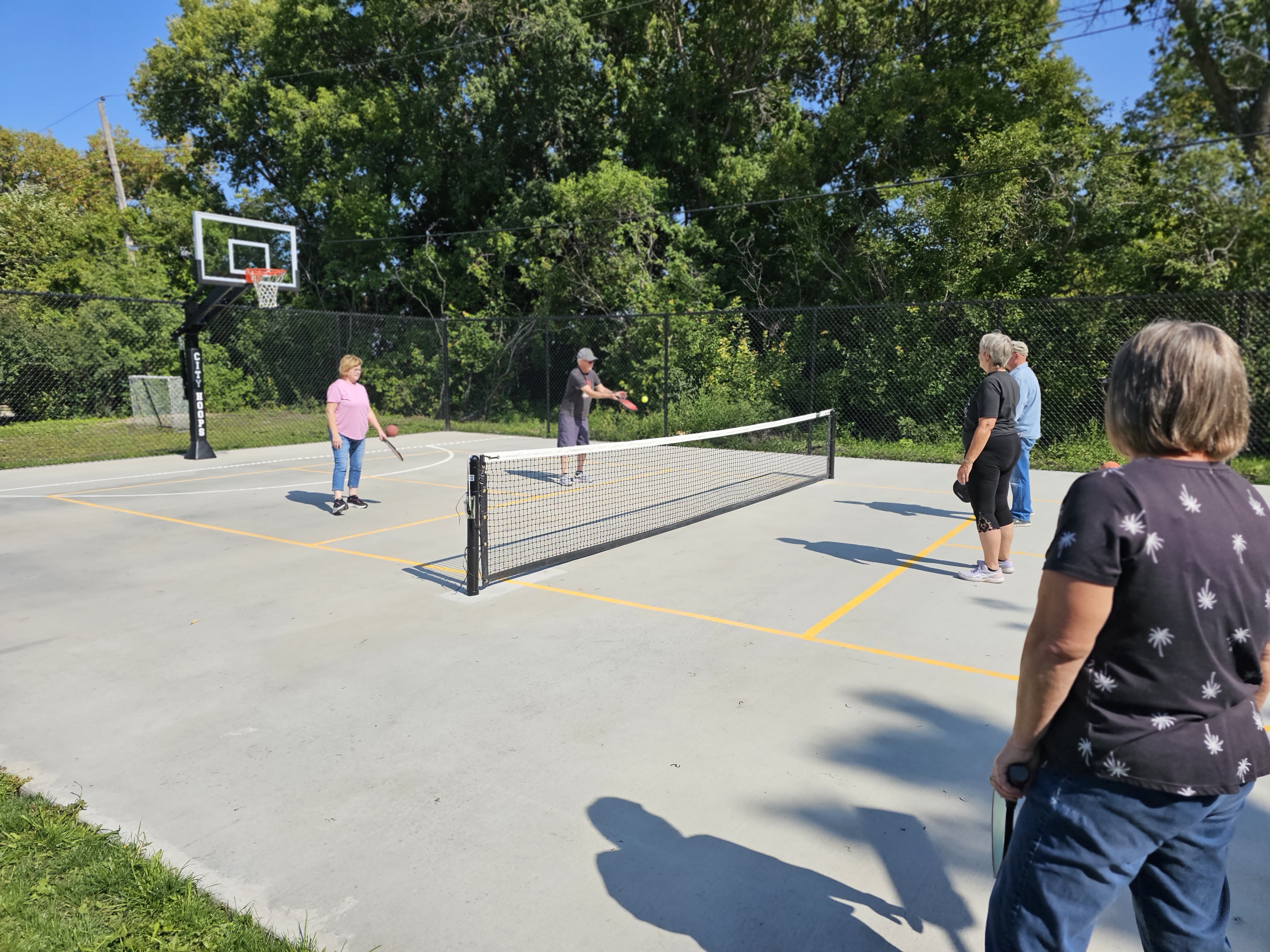 Residents playing pickleball on the new court