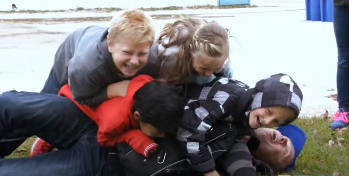 kids dogpile on Corny Rempel