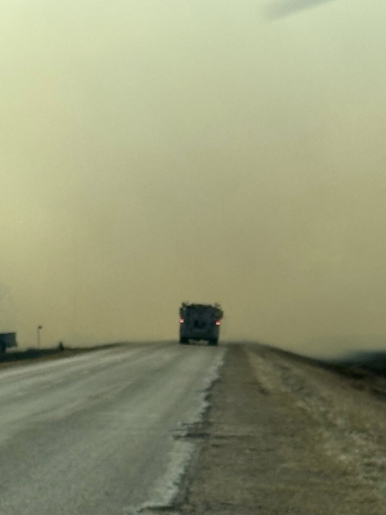 Heavy smoke from wildfires near Sandy Bay Ojibway First Nation hangs heavy over a Manitoba highway, April 2025, significantly reducing visibility for drivers in the region.