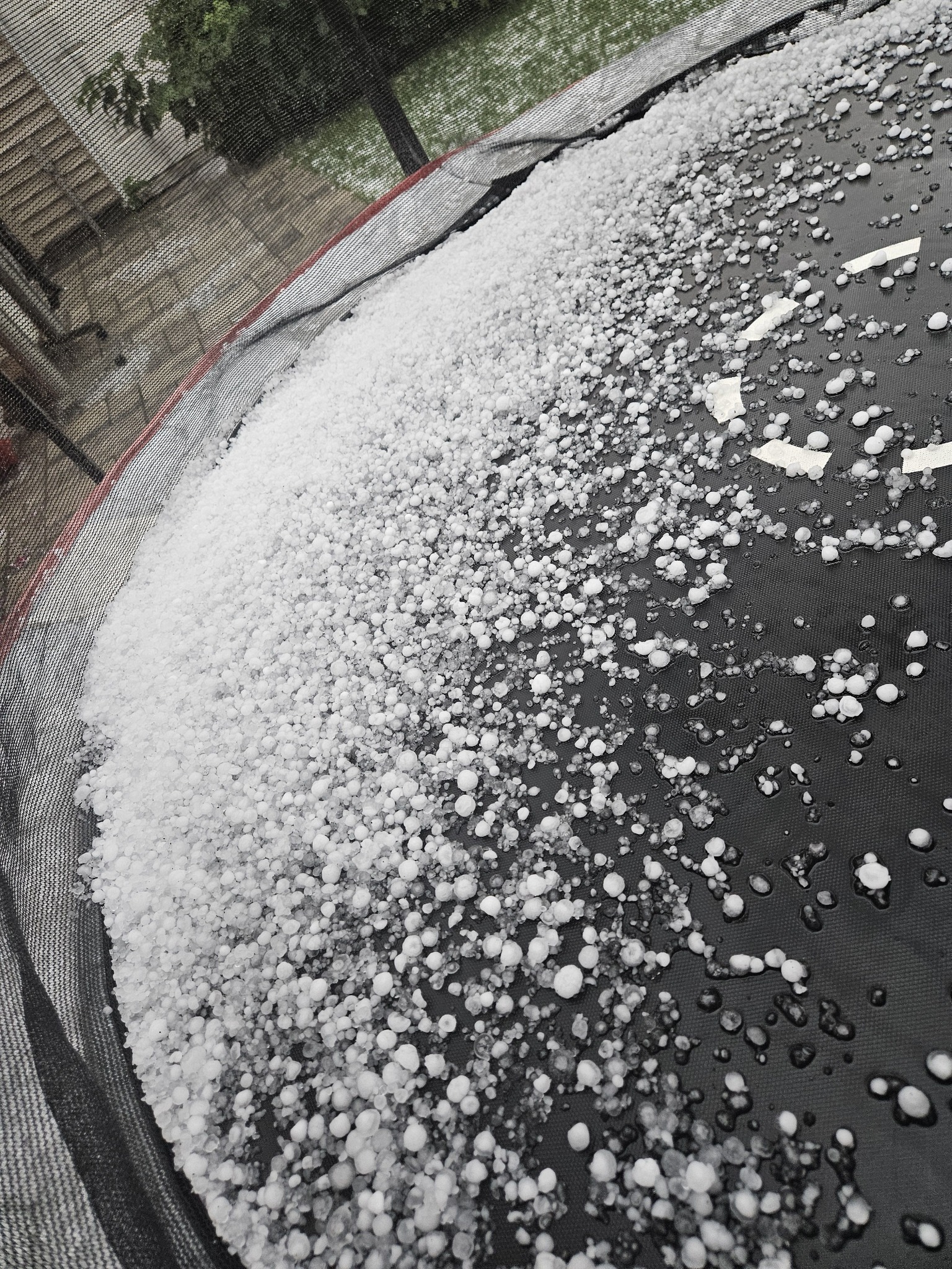 Hail blankets a backyard trampoline in Airdrie during Monday’s thunderstorm.
