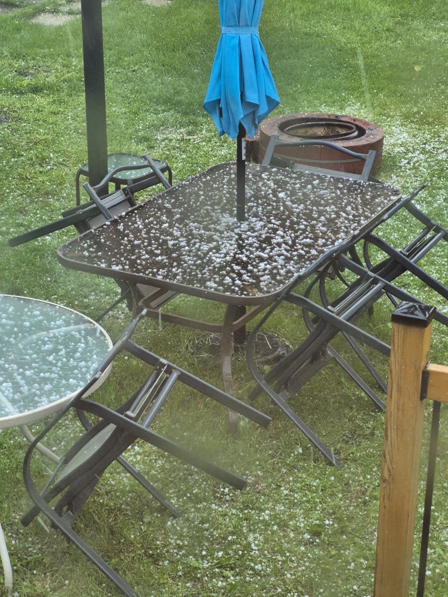 Patio furniture sits scattered and covered in hail as a storm moved through Airdrie on Monday afternoon.