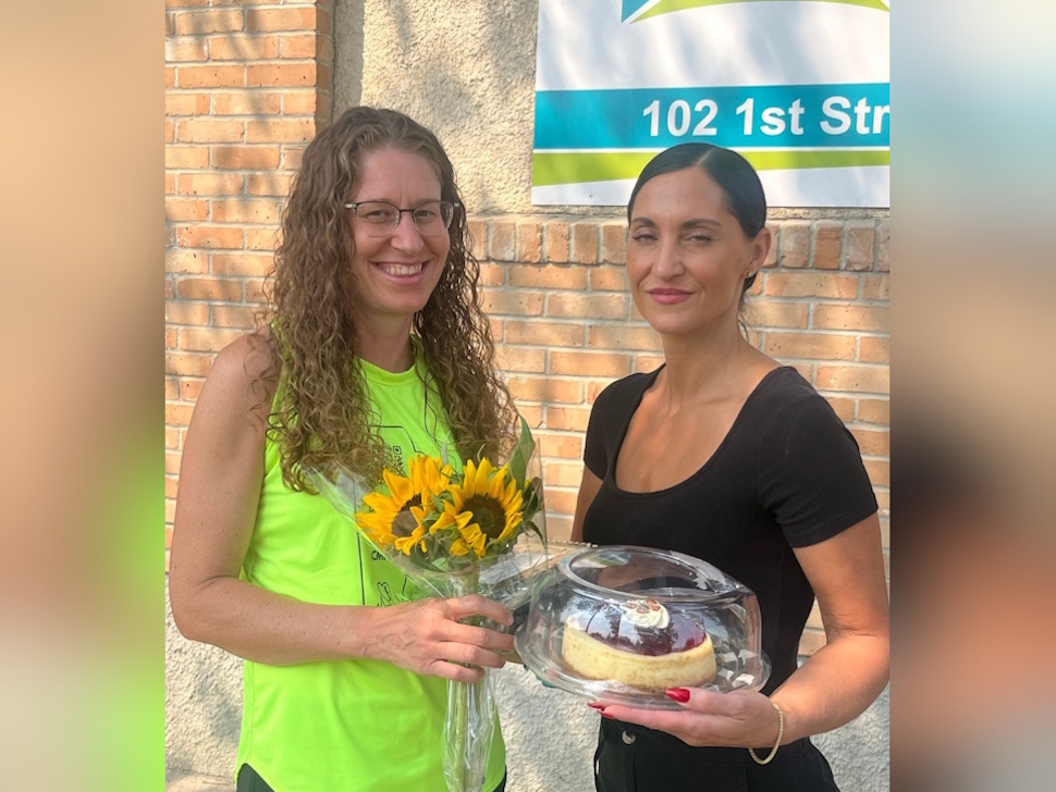 Christina Allingham of the Canadian Mental Health Association surprised Diane Wing with a cake and sunflowers for her birthday, celebrated shortly after Wing completed her 500-kilometre run across Manitoba in support of mental health and suicide prevention. Submitted Photo/Diane Wing