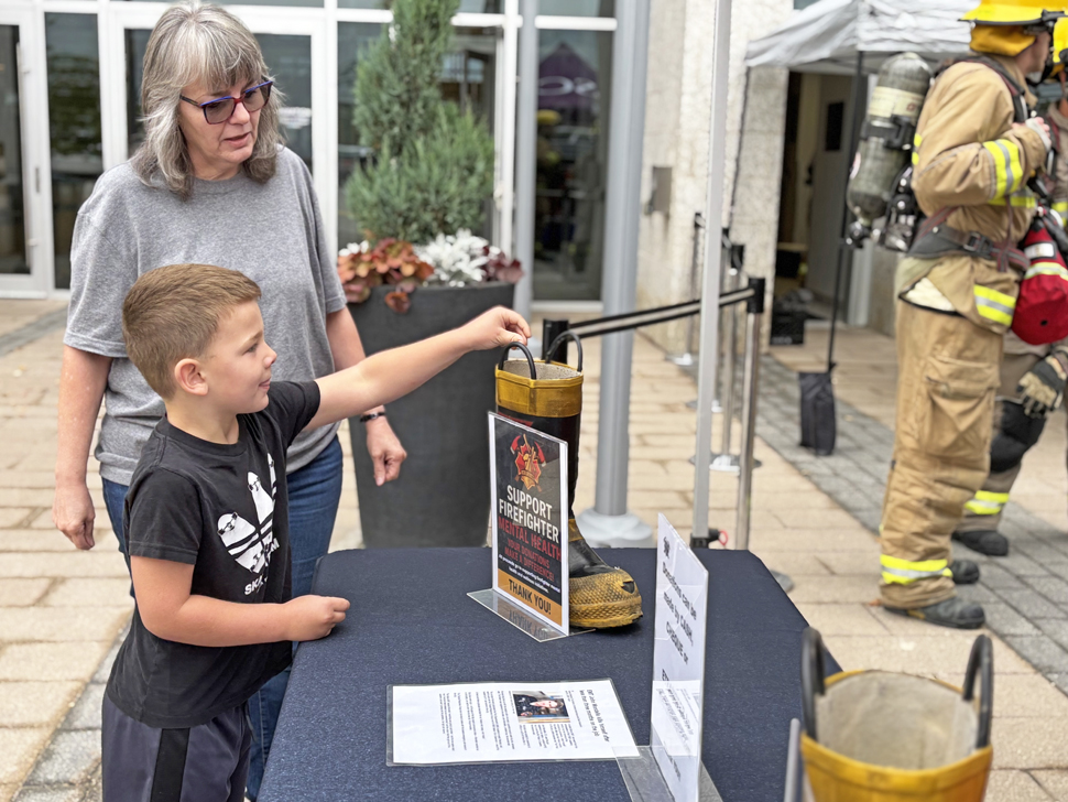 A young boy makes a donation to the Steinbach Fire Department during the stair-climb event.