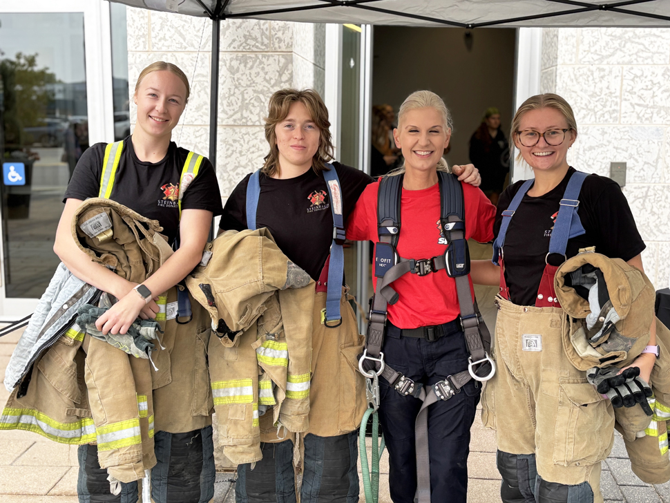 Lieutenant Cindi Klassen-Krahn stands with 3 new recruits before they take to the stair climb.