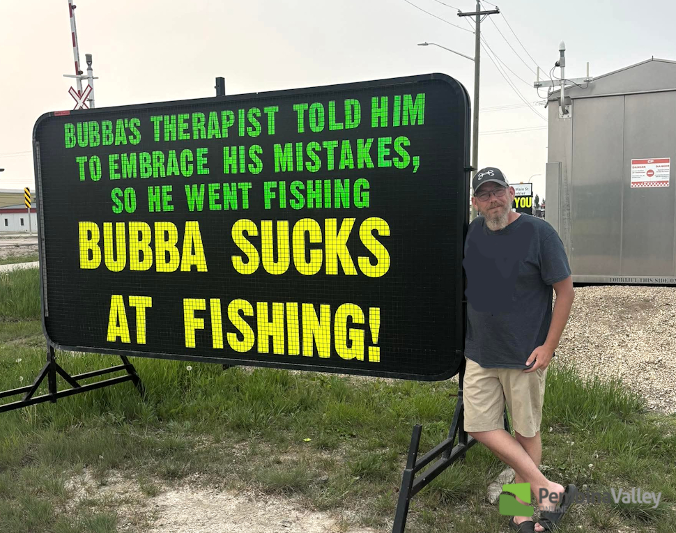 a man stands beside a sign