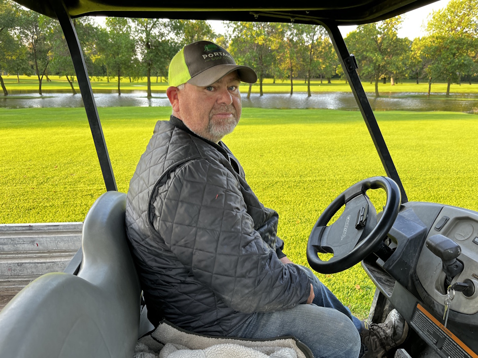 Portage Golf Club superintendent Farrol Asham sits in a golf cart while inspecting flooded fairways after an overnight storm.
