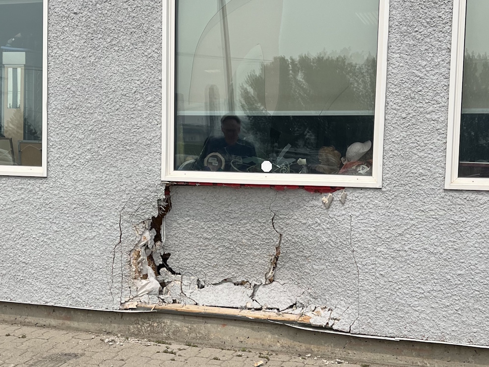 Exterior of GME Thrift Emporium showing the cracked and pushed-in south wall caused by a car crash.