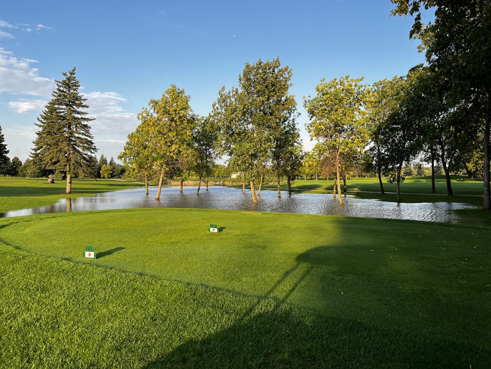 Flooded area near a tee box at Portage Golf Club, with water covering the grass and fairway.