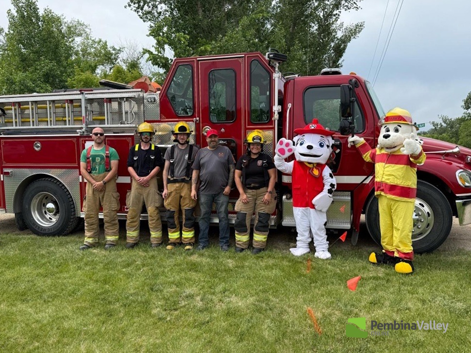 Fire fighters stand next to a fire truck at the Montcalm Heritage Festival