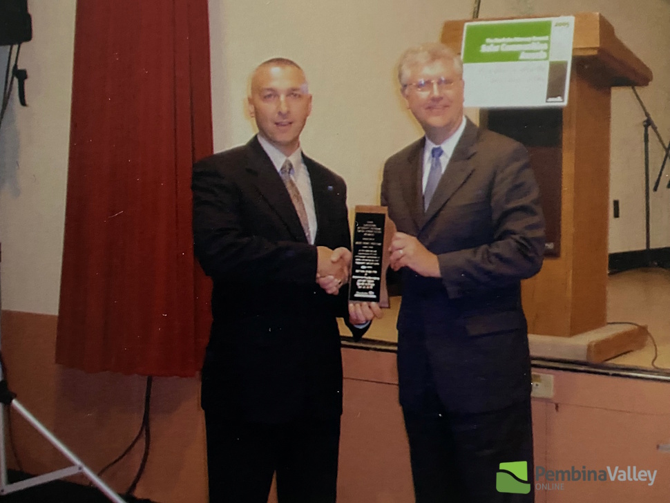 two people pose with an award