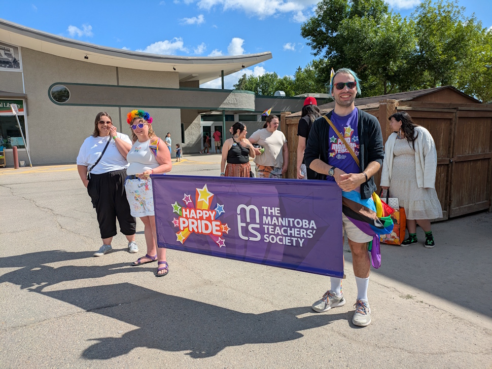 The Manitoba Teachers' Society, smiling with their banner before the Pride Walk began. PortageOnline/Maryssa McFadden