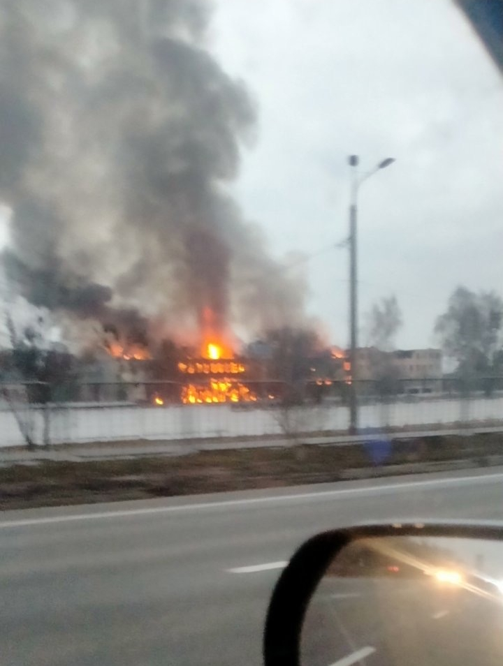 Bombing scene in Ukraine with fire in distance from a large building