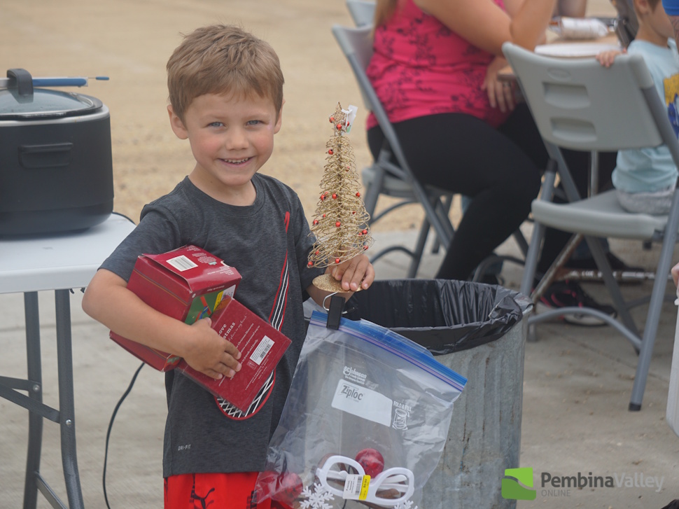 a boy holding Christmas decorations
