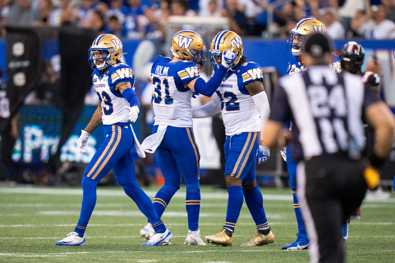3 Blue Bombers players celebrate midfield