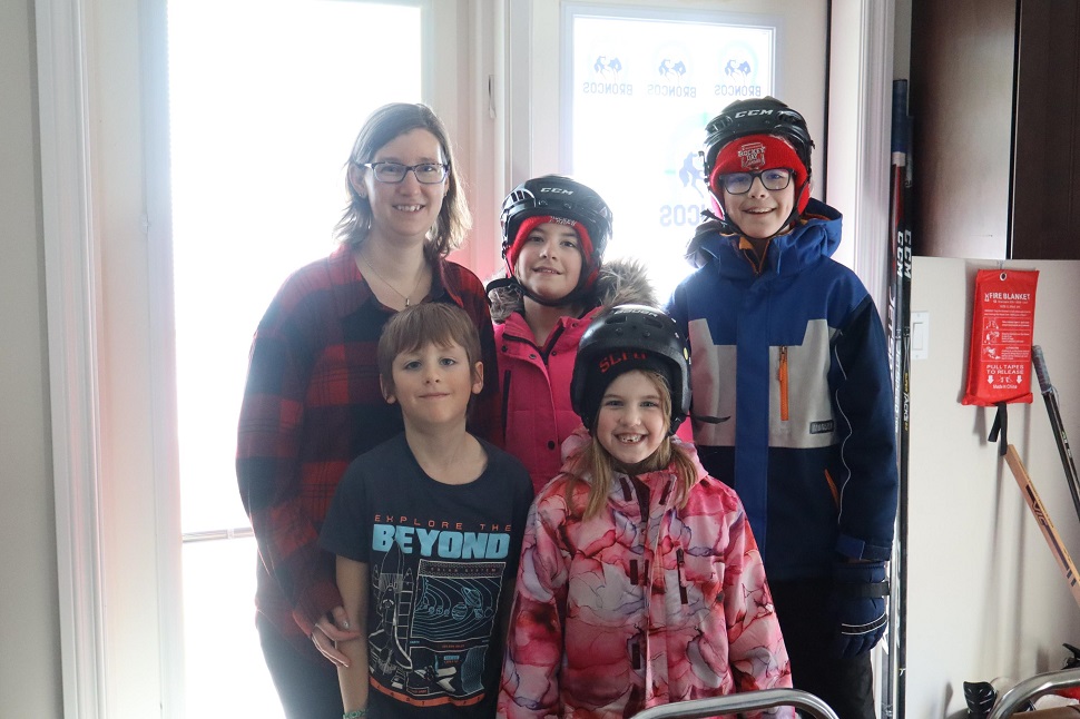 Amy (rear right) stands with Aniya (rear centre), Alem (rear right), Ayrton (front left) and Arabel (front right) at the door that leads out to the ice course.