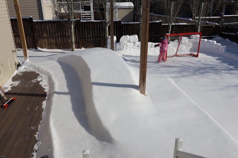 The ice surface does contain a hockey rink, right next to a raised portion that flows and bends over the deck. 