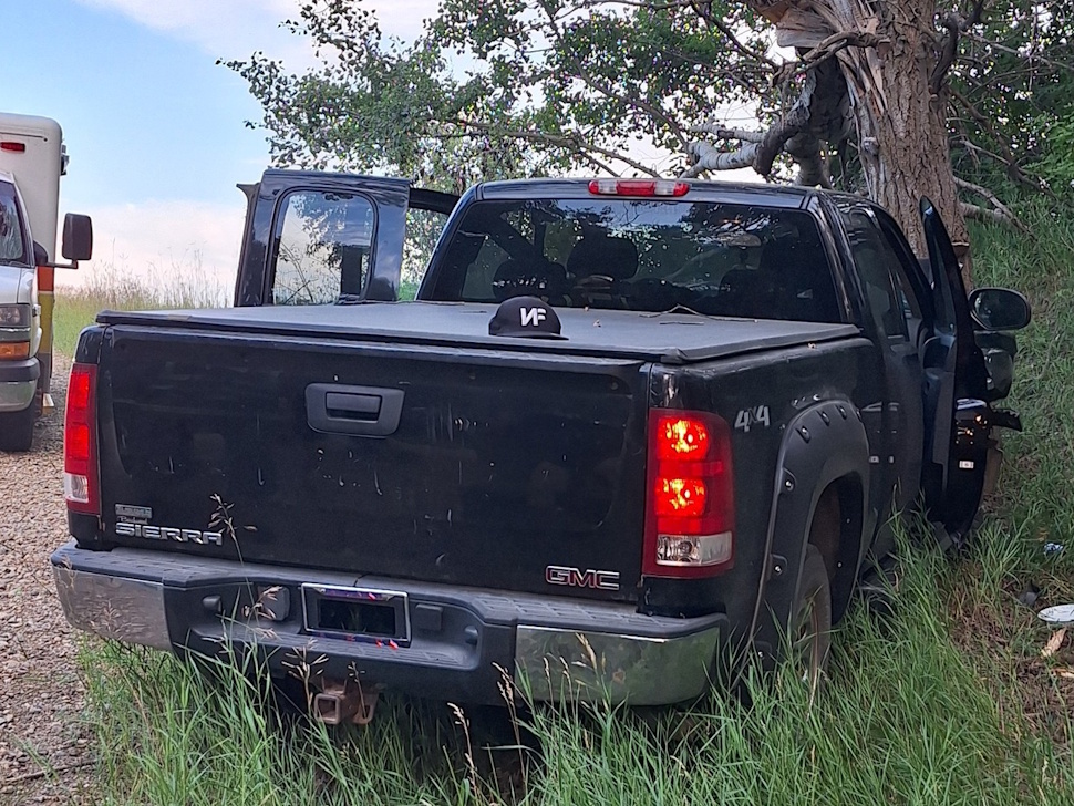 Rear view of a damaged pickup truck in a ditch after a collision.