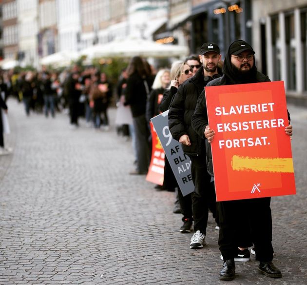 People stand holding signs