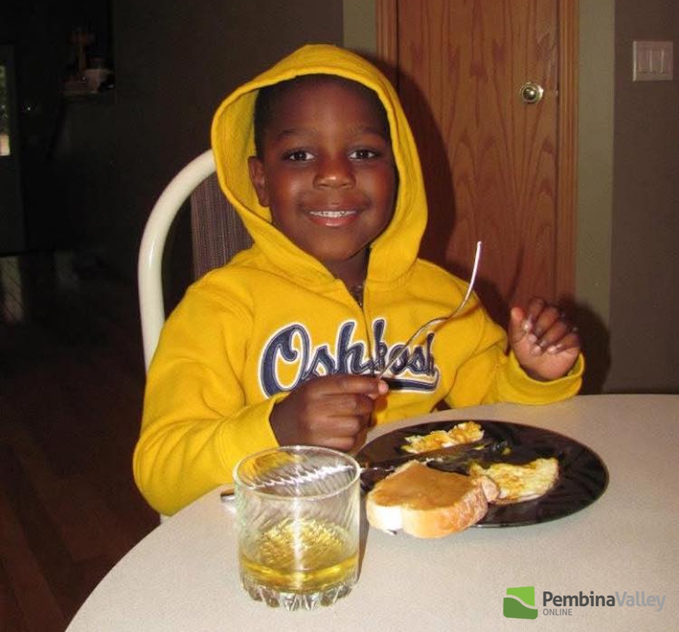 a young boy sits at a table