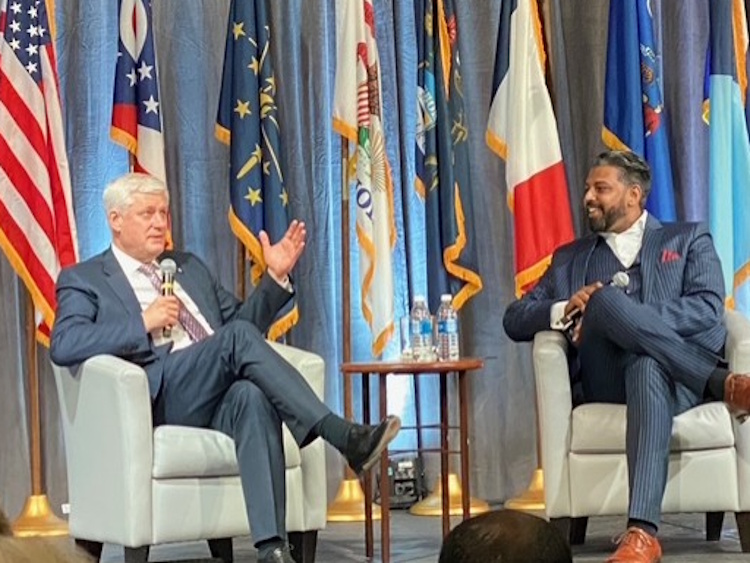 Stephen Harper speaking on stage during a panel discussion at the Midwest conference.