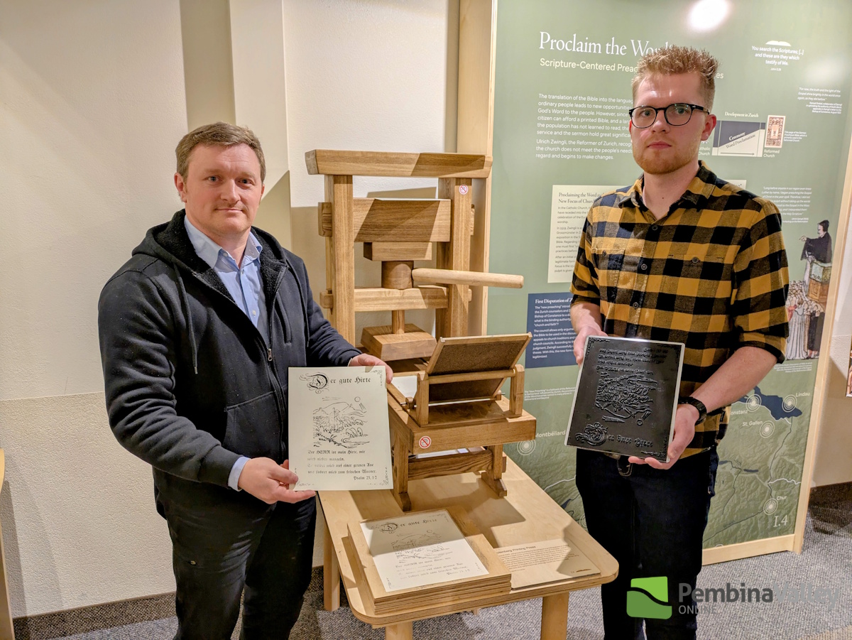 Left to right; Andrew Harder and Jonathan Krause next to a replica of an early printing press used to produce translated Bibles