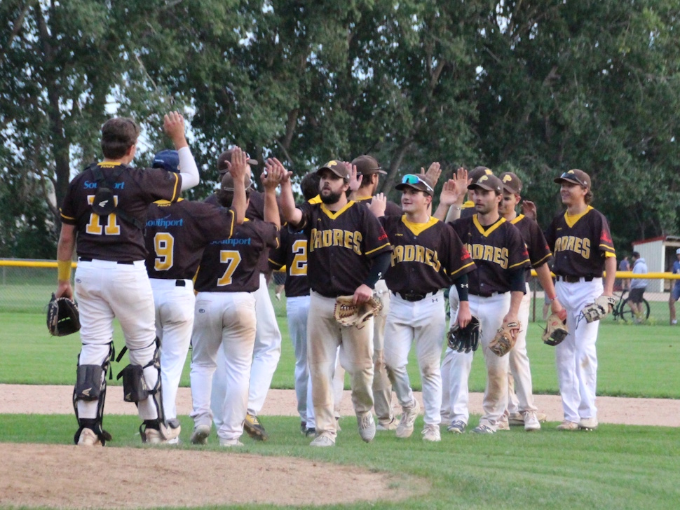 Portage Padres players celebrate on the field, high-fiving each other after winning Game 5 of the SCBL championship.