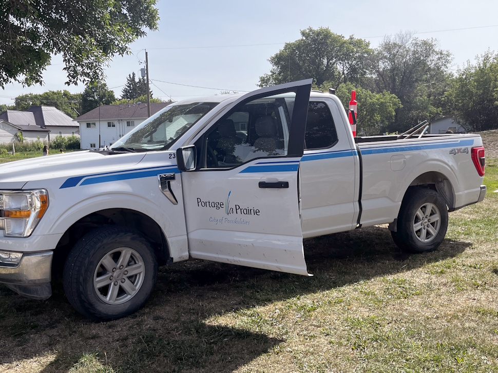 A City of Portage la Prairie work truck parked near the splash pad at Simplot Park during cleanup efforts.