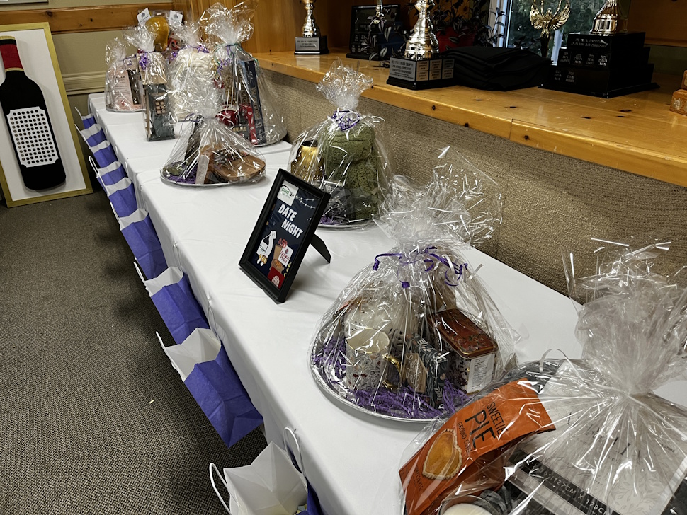 A display of rainbow auction items at the Sip and Stroll fundraiser, featuring various donated goods and prizes.