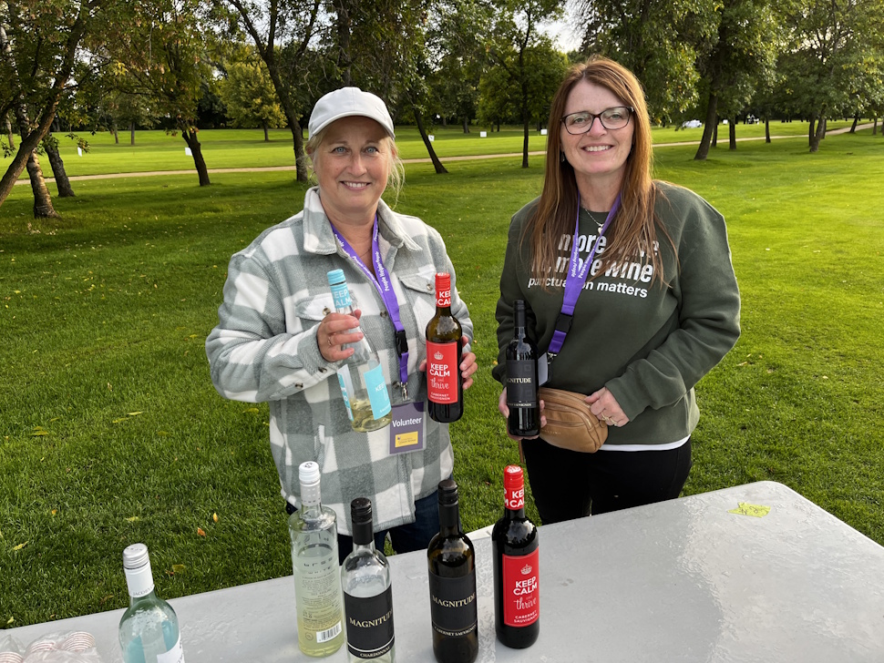 A Sip and Stroll tasting station at the Portage Golf Club, featuring a selection of wine, beer, and whiskey for participants to sample.