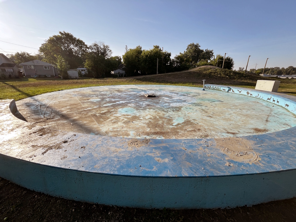 Close-up view of mud, rocks, and debris scattered across the surface of the splash pad at Simplot Park.