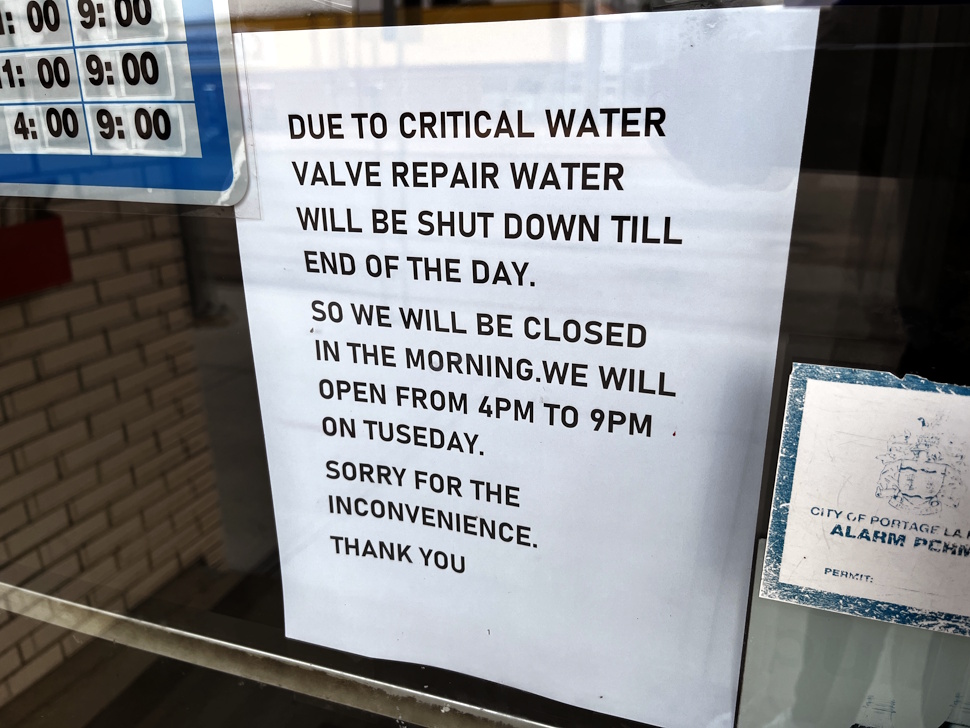 Photo of a storefront sign reading "Closed Today Due to Water Shutoff."