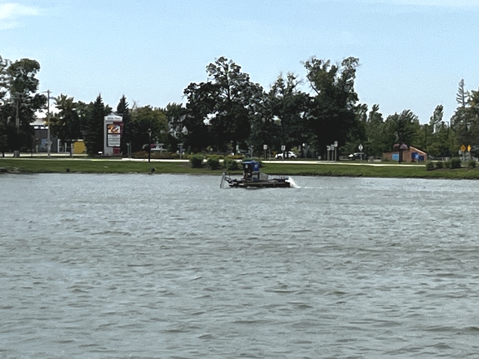 A mechanical weed harvester operating on Crescent Lake, removing excess aquatic vegetation.