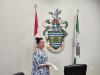 Mayor Knox showcases the city's Coat of Arms inside council chambers