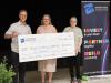 people stand behind a large cheque 