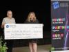 people stand behind a large cheque 