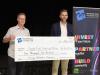 people stand behind a large cheque