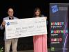 people stand behind a large cheque 