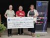 people stand behind a cheque