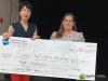 two women stand behind a giant cheque 